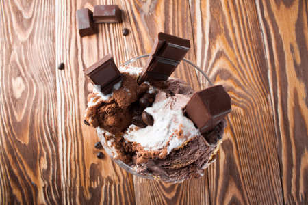 Ice cream with chocolate in the vase on a wooden board.の写真素材