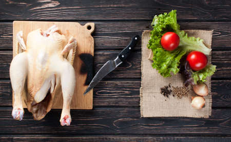 Chicken carcass with vegetables on wood deskの写真素材