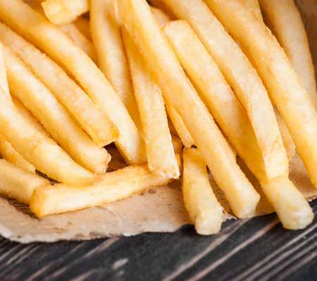 pile of appetizing french fries on a white background