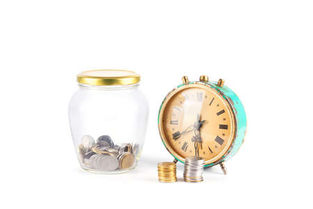 Old clock and coins on a white background. Concept of savings. Deposit