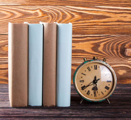 Old books and clock on the wooden boardの写真素材