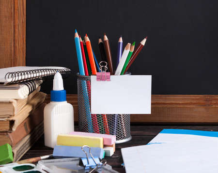 School board and stationery on wooden table. School concept