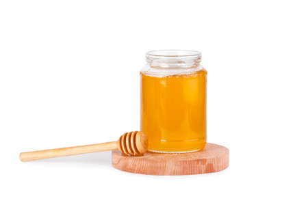Jar of honey and  honey dipper on a white backgroundの写真素材