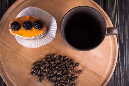 spoon ground coffee with coffee beans with cake on wood deskの写真素材