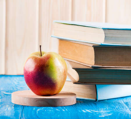 Stack of books and apple on a blue wooden shelf. Knowledge conceptの写真素材