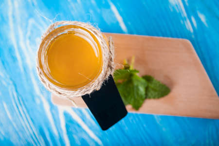 Jar of honey and spoon for honey on the blue boardの写真素材