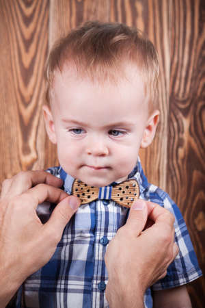 Father helping son to adjust a bow tie. Preparation before important eventのeditorial素材