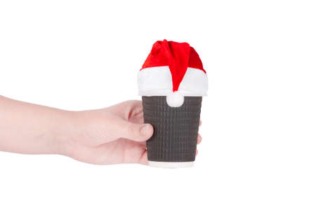 disposable cup of coffee in santa hat  in hand isolated on white backgroundの写真素材