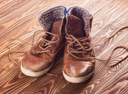 Old brown sneakers on wood background.の写真素材