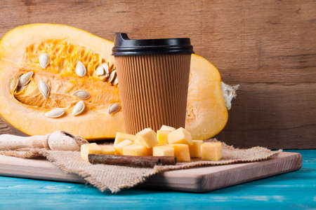 Slice pumpkin and coffee cup on wood desk.の写真素材