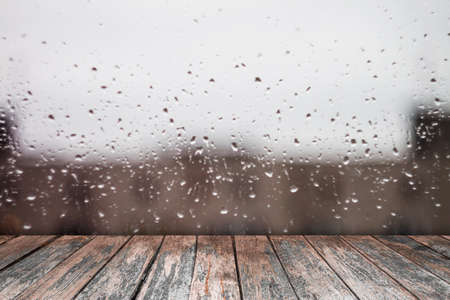 Drops on the window and wood desk.の写真素材