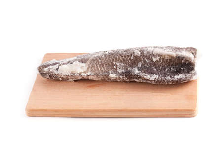 Frozen sea fish on a wooden chopping board isolated on white background