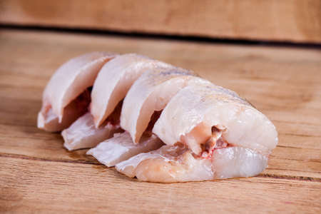 Fillet of pike close up on wood desk.