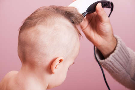 The father of the child cuts clipper. Family values