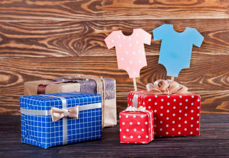 Decoration for Baby shower on wood desk. Color garland from infant shirt. Gift boxの写真素材