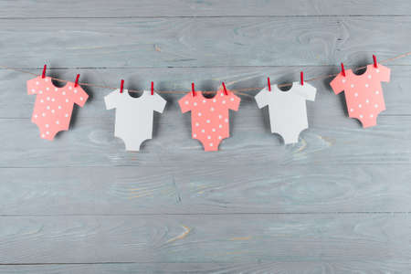 Decoration for Baby shower on wood desk. Color garland from infant shirt. Gift boxの写真素材