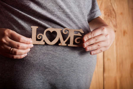 Image of pregnant woman touching her belly with hands