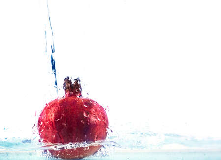 Photo ripe fresh pomegranate in water isolated on white backgroundの写真素材