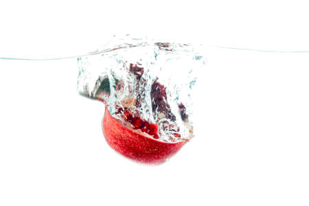Photo ripe fresh pomegranate in water isolated on white backgroundの写真素材
