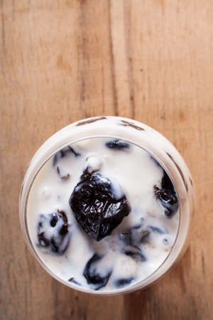 Desserts with prune, walnut and sour cream in vase. Food backgroundの写真素材