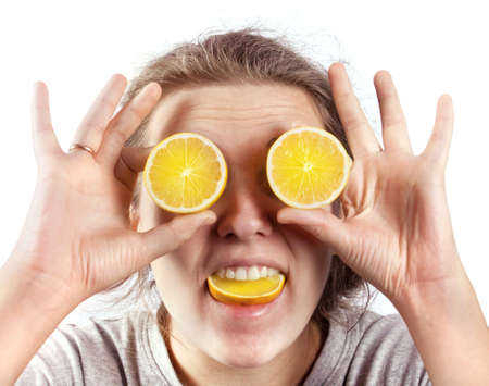 Woman holds a lemon at eye level.  Funny womanの写真素材