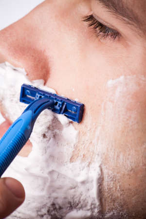 Time for new razor. Close-up young shirtless man holding razorの写真素材