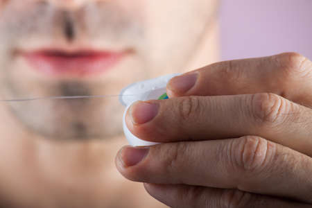 New dental floss on the background of the person. Dental care