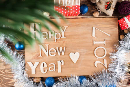 Wood inscription Happy New Year close up with snow. Greeting card