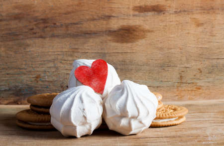 White fresh marshmallows with red heart on wood desk. Sweetsの写真素材
