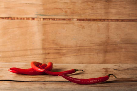 Red fresh chili on wood desk. Food background. Cookingの写真素材