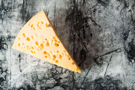 Piece of cheese close up on wood desk. Food backgroundの写真素材