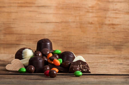 Chocolate candy on wood desk, chocolates with nutsの写真素材