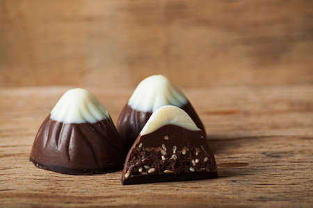 Chocolate candy on wood desk, chocolates with nutsの写真素材