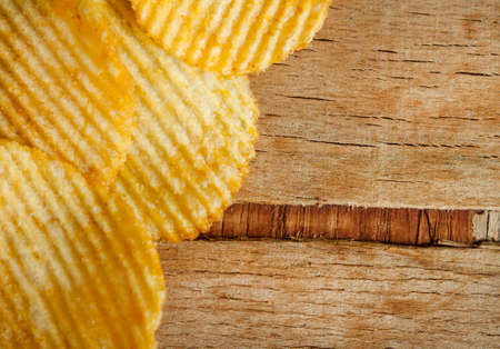 Fried potato chips corrugated on wood desk. Food