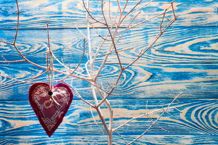 Heart made of cloth on white branch. Valentine day. Holidays card with copy spaceの写真素材