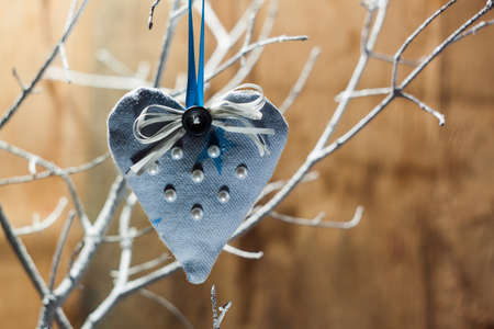 Heart made of cloth on white branch. Valentine day. Holidays card with copy spaceの写真素材