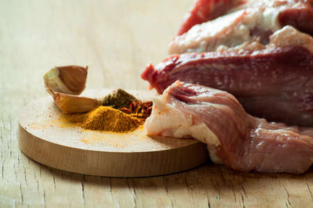 Piece of meat and  seasoning  on wood desk. Food ingredientsの写真素材