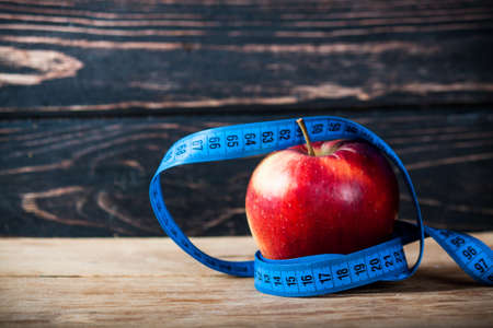 Fresh apple with measuring tape on wood deskの写真素材