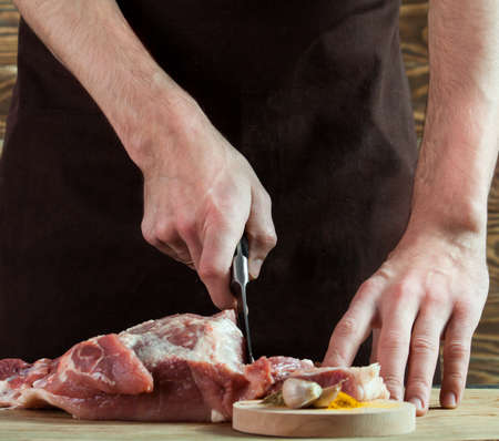 Butcher cutting pork meat on kitchen. Food backgroundの写真素材