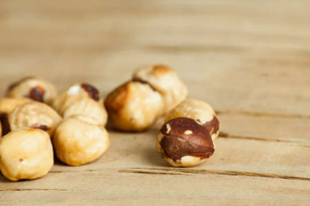Roasted hazelnuts close up on wood desk. Food
