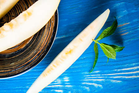 Slice melon on wood desk close up. Food backgroundの写真素材