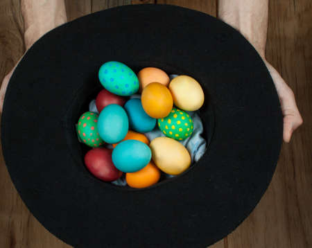 Colorful easter eggs in hand on wood deskの写真素材
