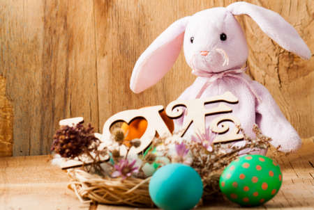 Colorful easter eggs and rabbit close up on wood desk