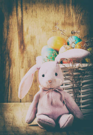 Colorful easter eggs and rabbit close up on wood desk