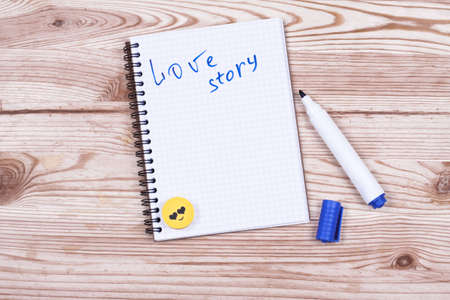 Book writing love story and pen on wood desk.の写真素材