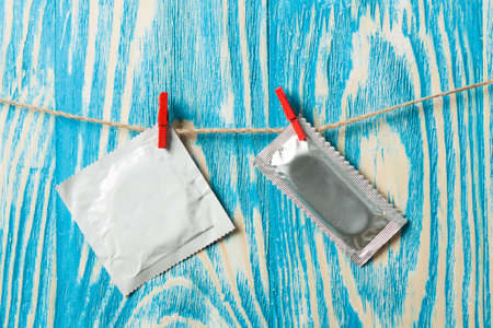 Condoms hanging on the rope on wood deskの写真素材