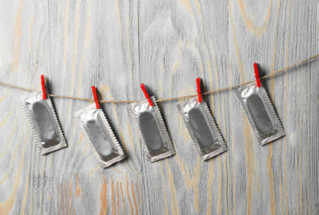 Condoms hanging on the rope on wood deskの写真素材