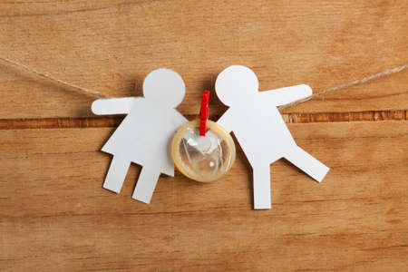 Condoms hanging on the rope on wood deskの写真素材