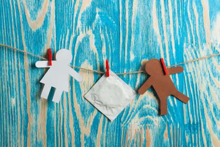 Condoms hanging on the rope on wood deskの写真素材