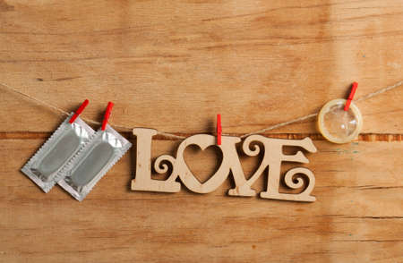 Condoms hanging on the rope on wood deskの写真素材